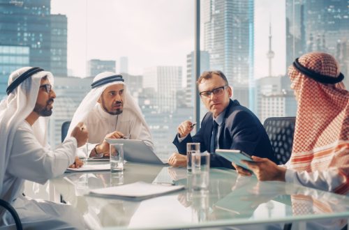 International Business Consultant Advices on Diversification of Investment Portfolio to Successful Arab Company Owners. Multicultural Meeting in Modern Office Between American and Emirati Businessman