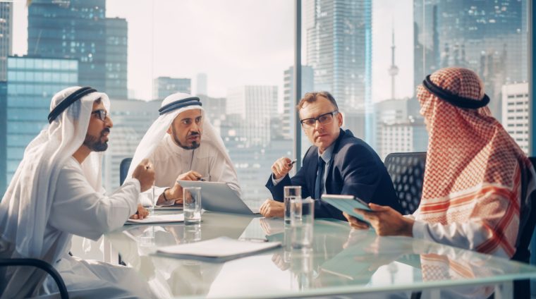 International Business Consultant Advices on Diversification of Investment Portfolio to Successful Arab Company Owners. Multicultural Meeting in Modern Office Between American and Emirati Businessman